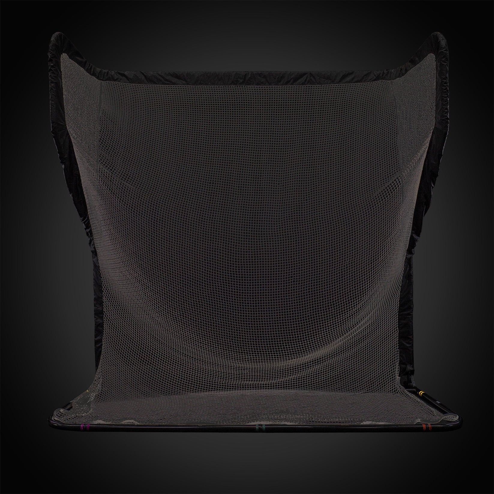 A large, black netted catching barrier set against a dark background.