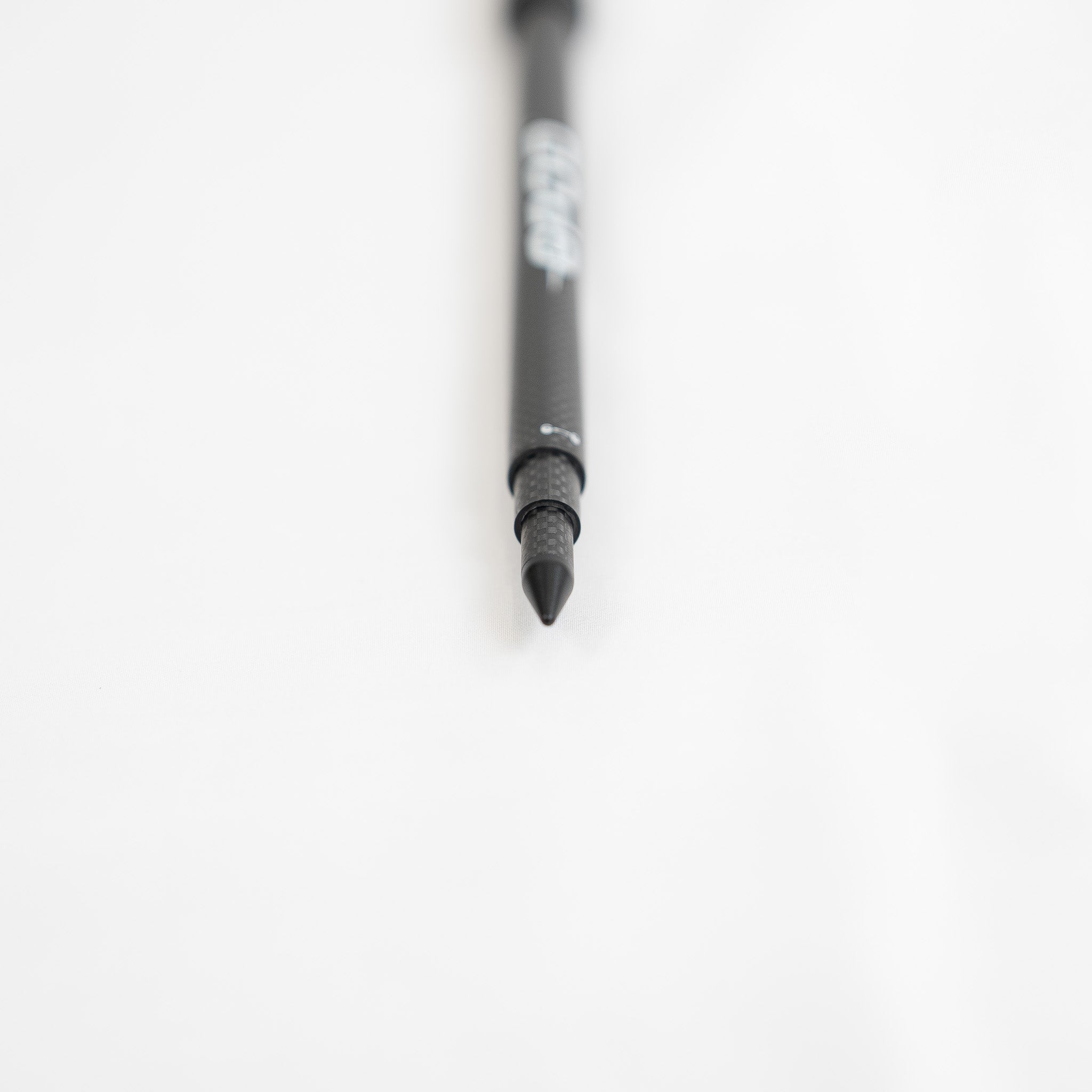 The GPOD GOLF GPOD X, featuring a sleek black design and sharp tip, is displayed on a white surface and photographed from the front, echoing the streamlined look of a portable monopod.