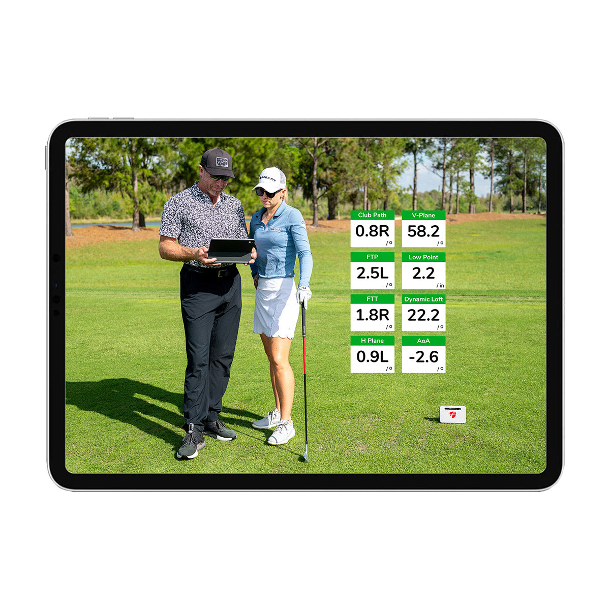 Two people stand on a golf course examining a tablet with FlightScope Golf's Pro Package, displaying bright golf data, including 3D club animations and swing plane information beside them.