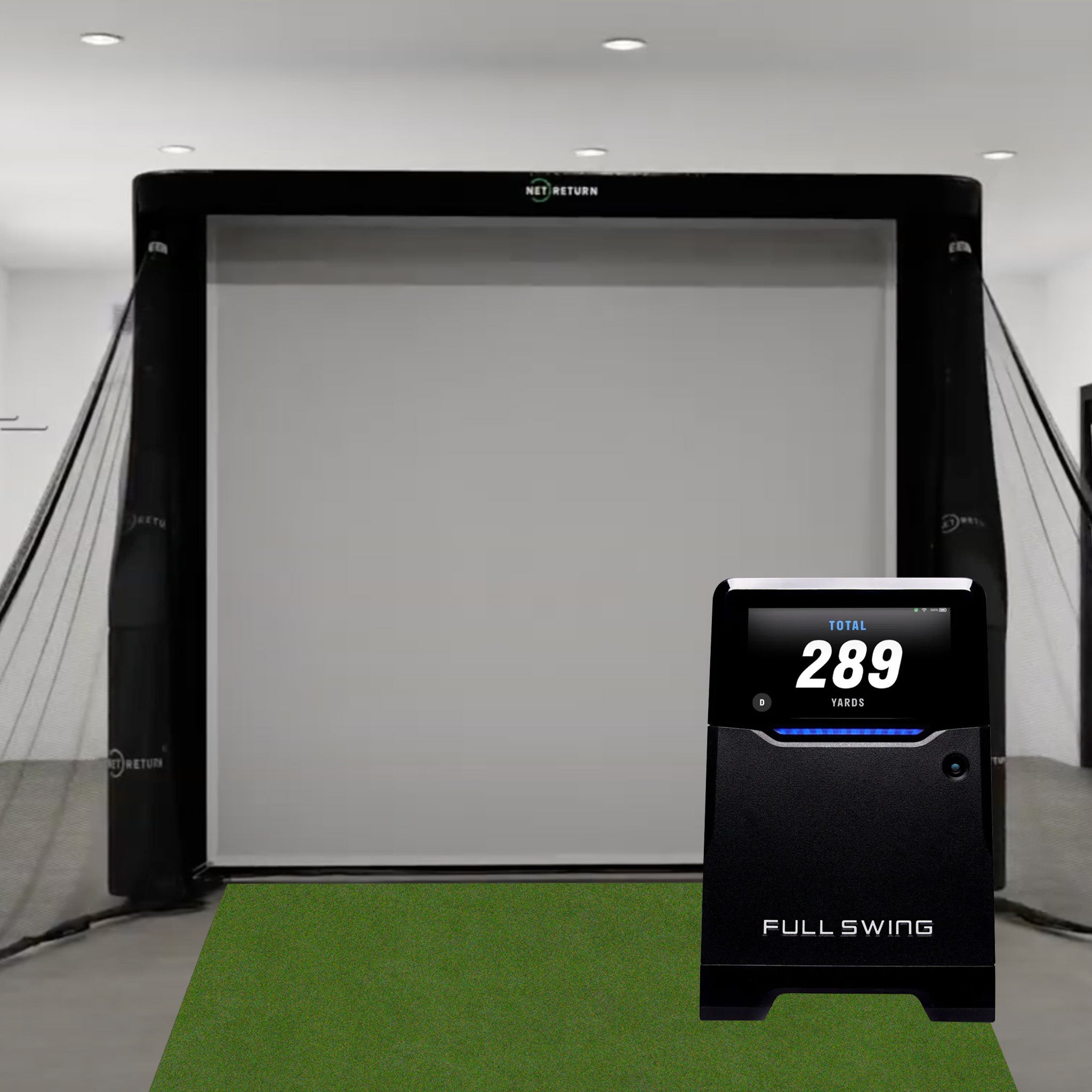 Golf simulator setup with a screen, side netting, and a Full Swing console displaying "Total 289 Yards.