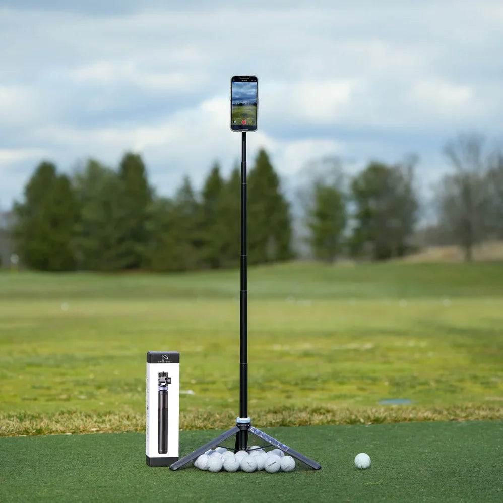 A smartphone on a GPOD GOLF GPOD Travel tripod stands on a golf course near golf balls, with Sportsbox 3D Player Annual + Swing Analysis bundle packaging nearby for easy swing analysis.