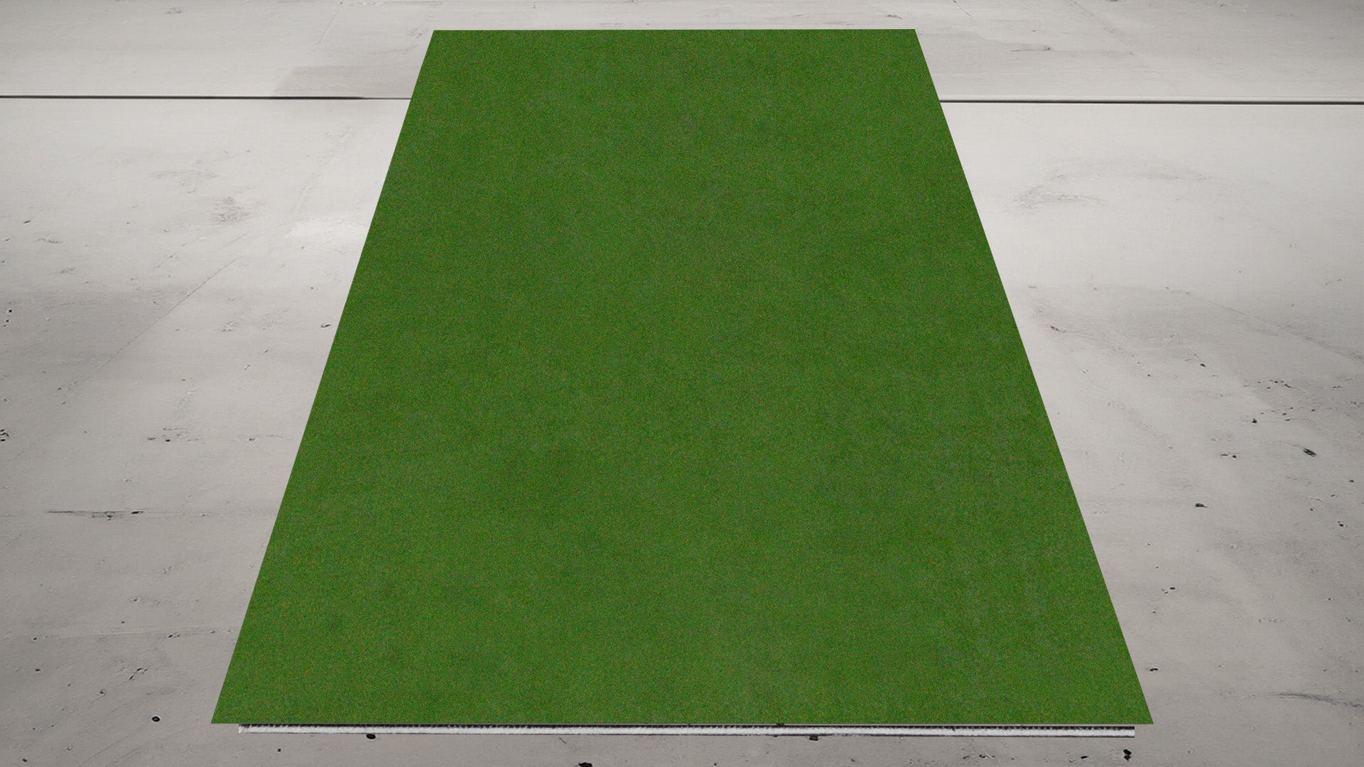 A rectangular, green synthetic turf mat is placed on a concrete floor in a well-lit indoor space.