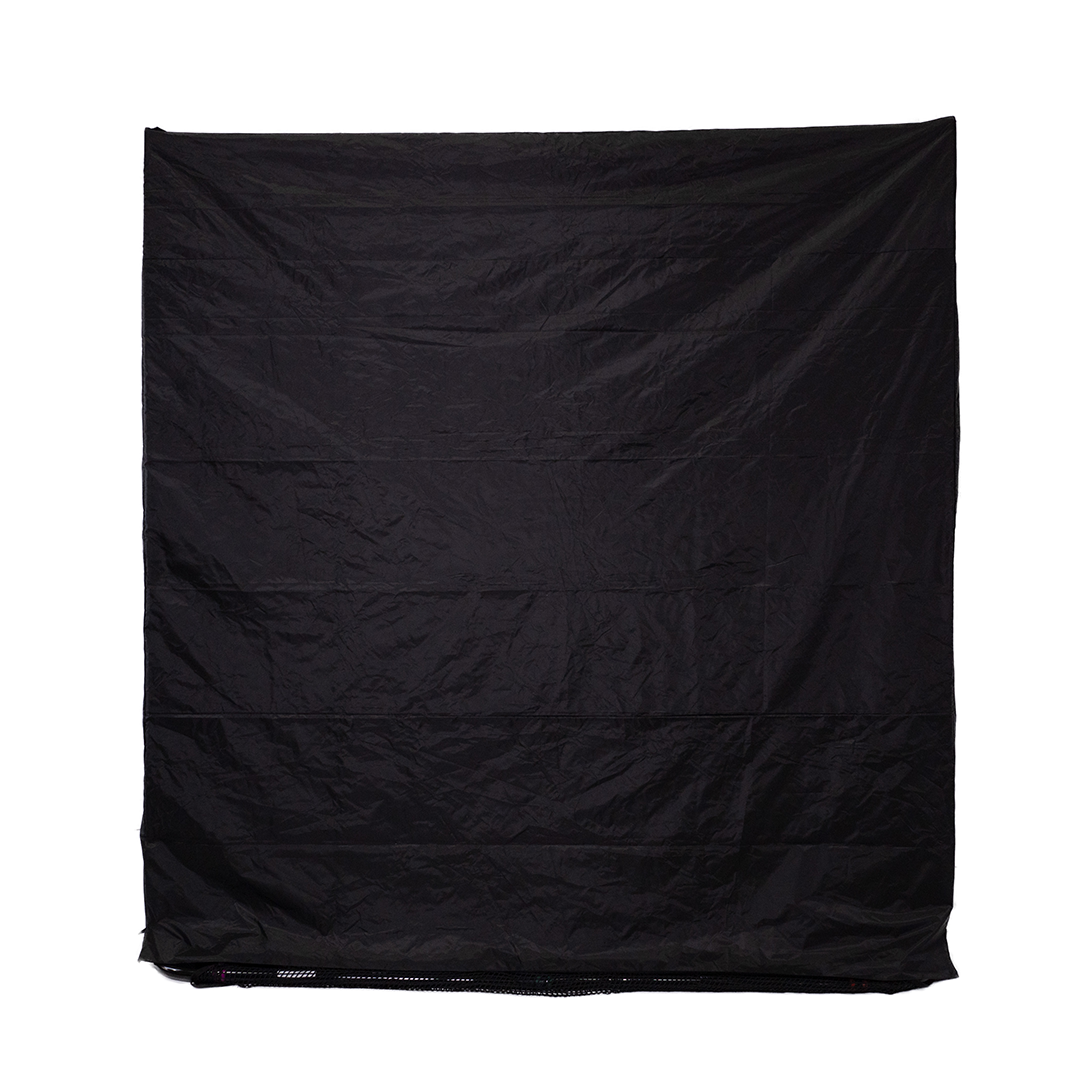 A large, crumpled black fabric sheet hangs against a plain white background.