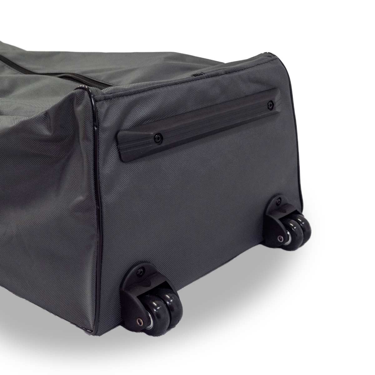 Close-up of a black rolling suitcase lying on its side, showing two pairs of wheels and a handle strip on the bottom.