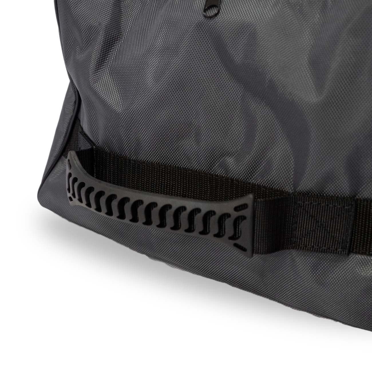 Close-up of a black fabric bag with a reinforced handle and textured strap detail.
