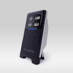 The Full Swing KIT, a black and white golf launch monitor by Full Swing, uses radar technology to display swing data like yards, degrees, and speed on its screen.