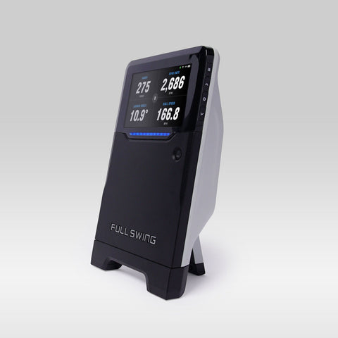 The Full Swing KIT, a black and white golf launch monitor by Full Swing, uses radar technology to display swing data like yards, degrees, and speed on its screen.